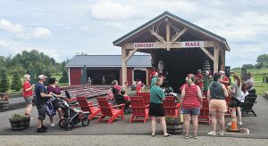 Families gathered at Santa’s Hideaway Hollow outdoor concert hall, where Santa and elves greet children.