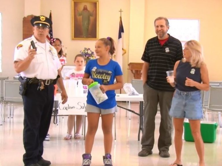 Cleveland Police Captain Keith Sulzer stands with 11-year-old Destiny Rice at her lemonade fundraiser for Patrolman Hank Adkins, joined by family and supporters inside Gloria Dei Lutheran Church.