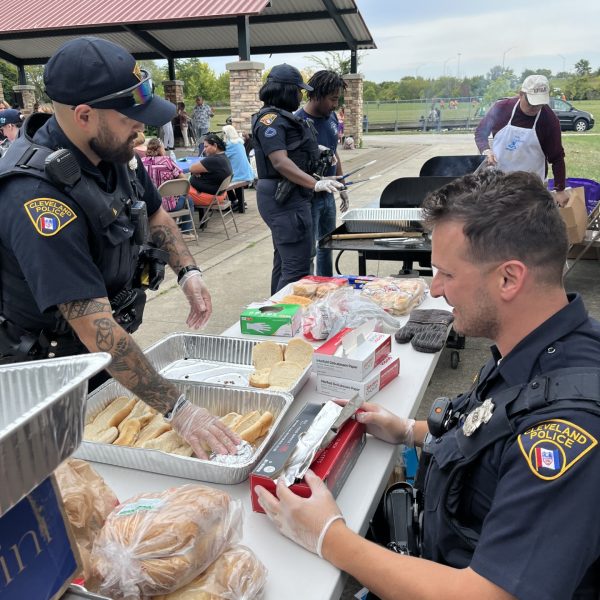 Second District officers serving hot dogs and burgers at the grill with volunteers.