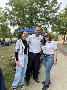 Officer posing with two attendees during the Safety and Resource Fair.