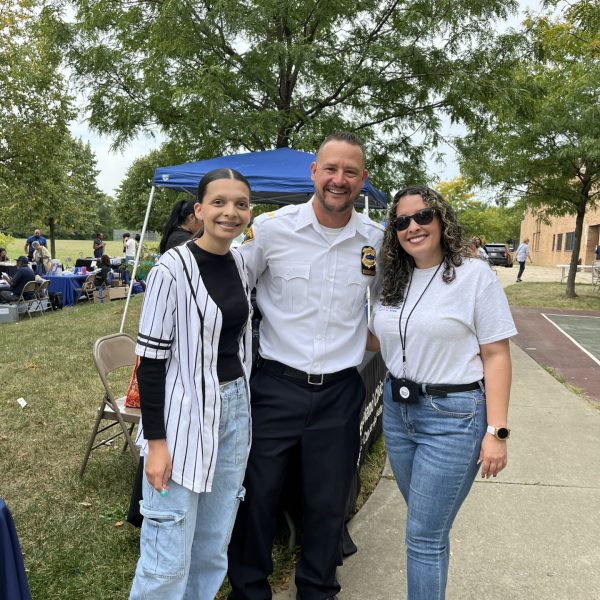 Officer posing with two attendees during the Safety and Resource Fair.