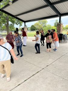 Community members dancing together under the pavilion during the fair.