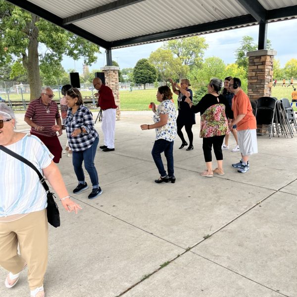 Community members dancing together under the pavilion during the fair.