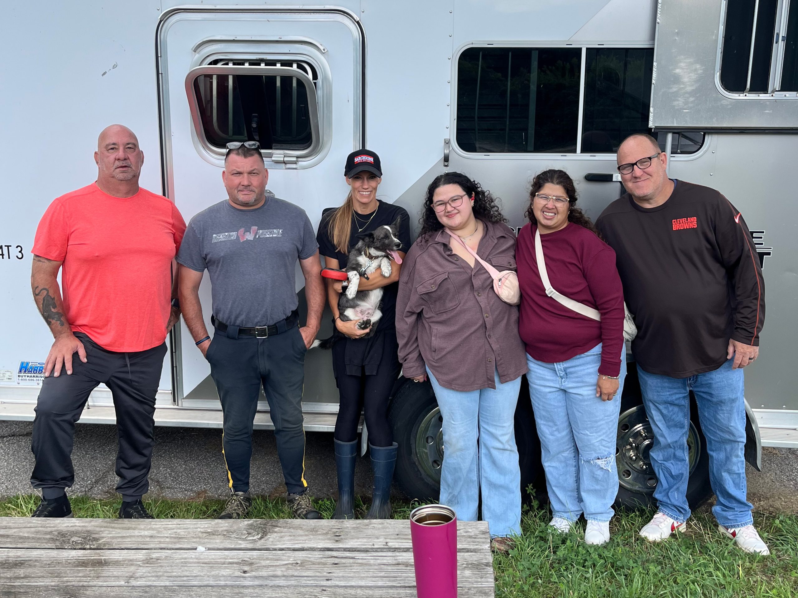 McKenzie Walsh with Cleveland Police Mounted Unit officers and supporters standing together in front of a horse trailer, one person holding a small dog.