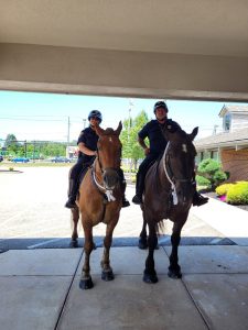 Two mounted officers side by side under a building overhang.