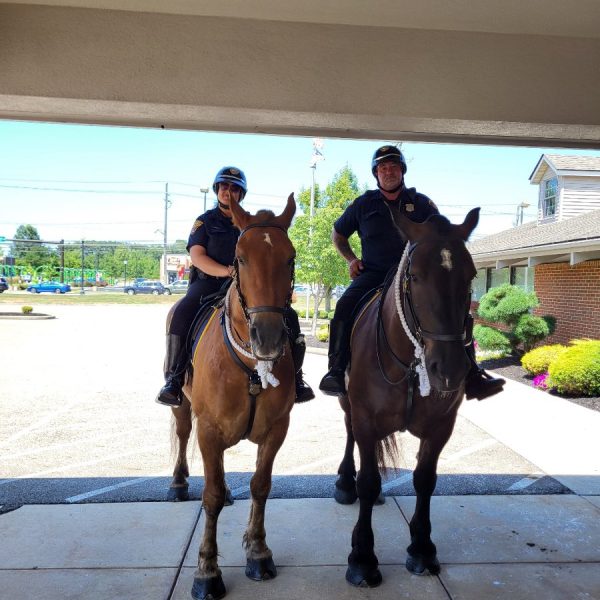 Two mounted officers side by side under a building overhang.