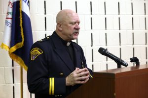 Father Doug Brown delivering the invocation at the podium.