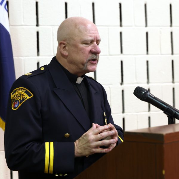 Father Doug Brown delivering the invocation at the podium.