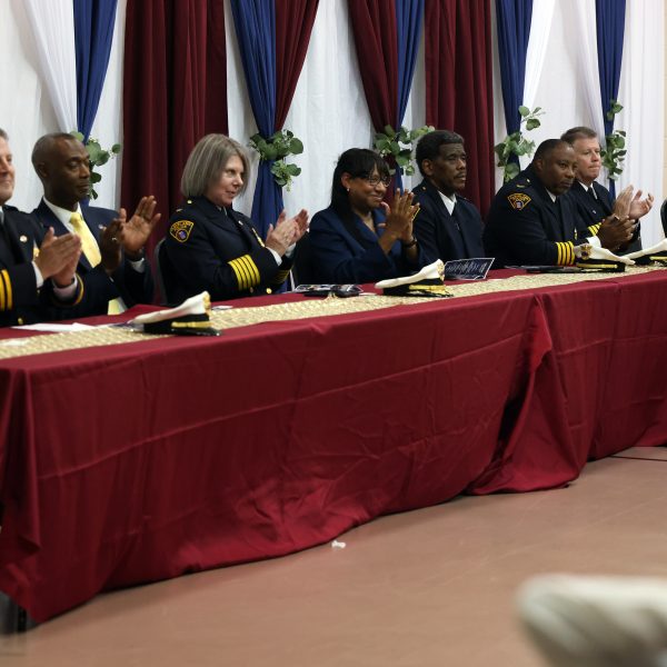 Panel of Cleveland Police officials and community leaders seated at the head table applauding.