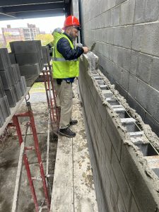 Lt. Lentz putting old skills to good use as he lays a block at the new headquarters.