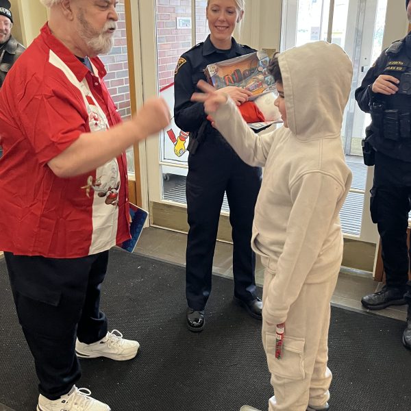 Santa Claus and a child share a moment while a Cleveland police officer stands nearby during the holiday visit.