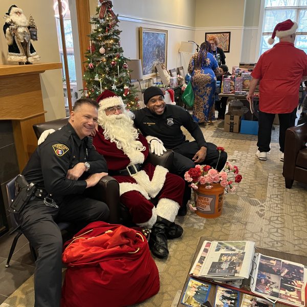 A volunteer stands next to a sign recognizing the long-running partnership between the Cleveland Police Department and the Ronald McDonald House.