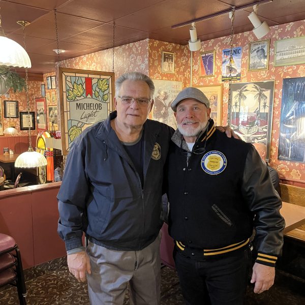 Bob Guttu standing beside Keith Sulzer inside a restaurant, posing together during a Coffee with a Cop event.