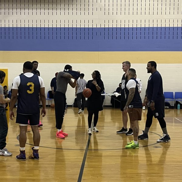 Players and officials gather at center court before the game at Willson School