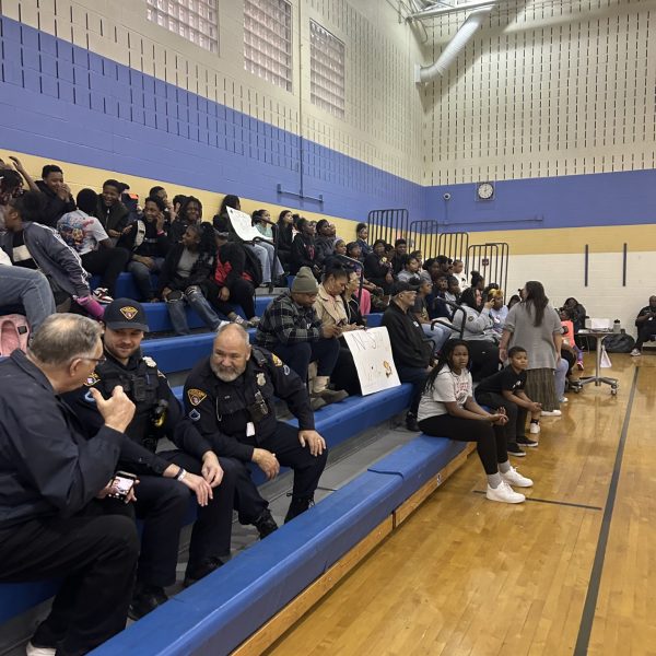 Officers and community members fill the bleachers at Willson School during the annual basketball game