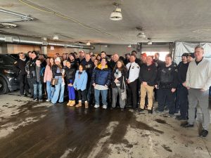 A large group of officers, family, and friends gathered inside the Second District garage to celebrate Officer Paul Beckwith's retirement
