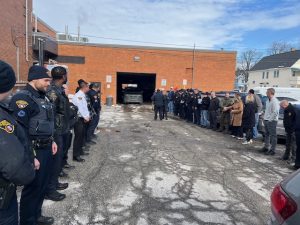Officers, family, and colleagues lined up in the Second District parking lot ahead of Officer Paul Beckwith's retirement sendoff