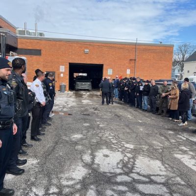 Officers, family, and colleagues lined up in the Second District parking lot ahead of Officer Paul Beckwith's retirement sendoff
